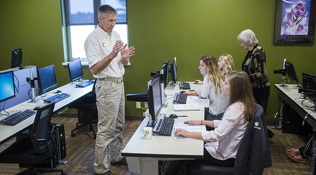 Students in a computer lab listening to an instructor