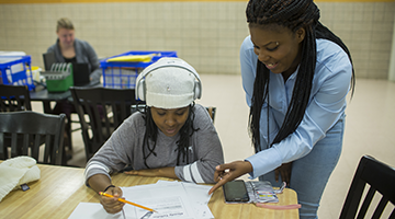 A Human Services Associate graduate helping a GED student with homework