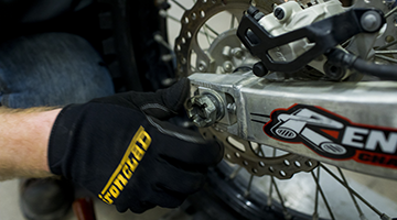 Close up of a student's hands working with tools in the power sports lab