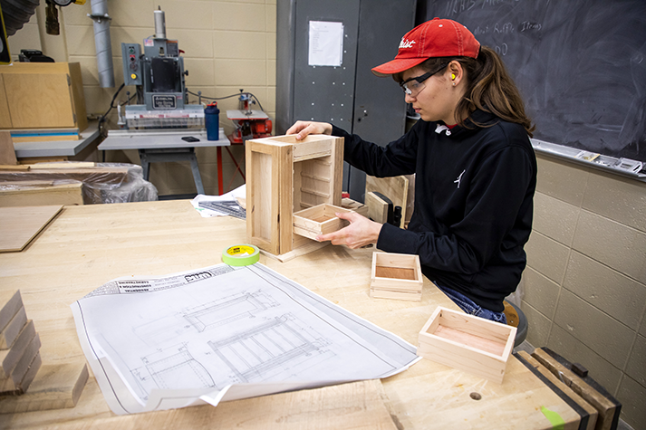 A student working on the production of a cabinet
