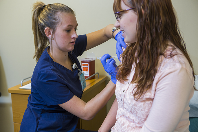 Medical Assistant student giving a flu shot to a patient