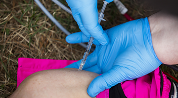 An EMT student practicing giving a shot