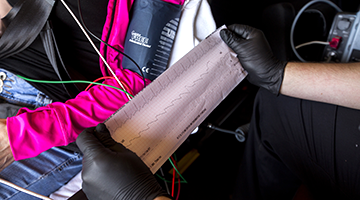 An EMT student holding a heart rate print out