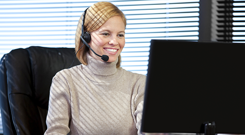 Executive Assistant at computer desk with headset on