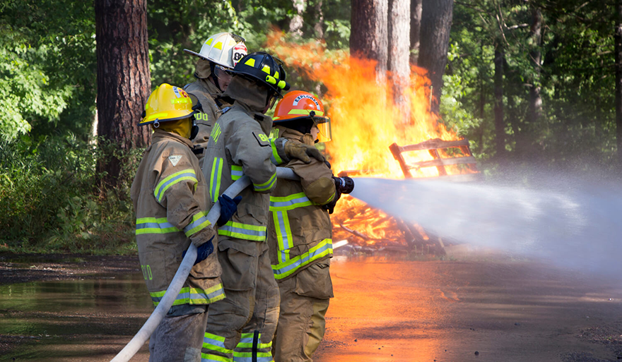 Students at the youth fire camp putting out a fire